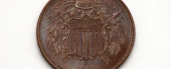 Close-up of an 1864 two-cent piece showing the shield design and the motto “In God We Trust.”
